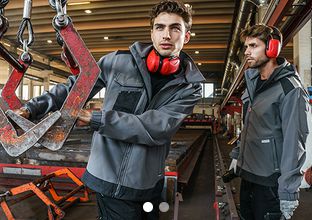 Zwei Männer mit PAYPER Arbeitsjacken in einer Werkstatt